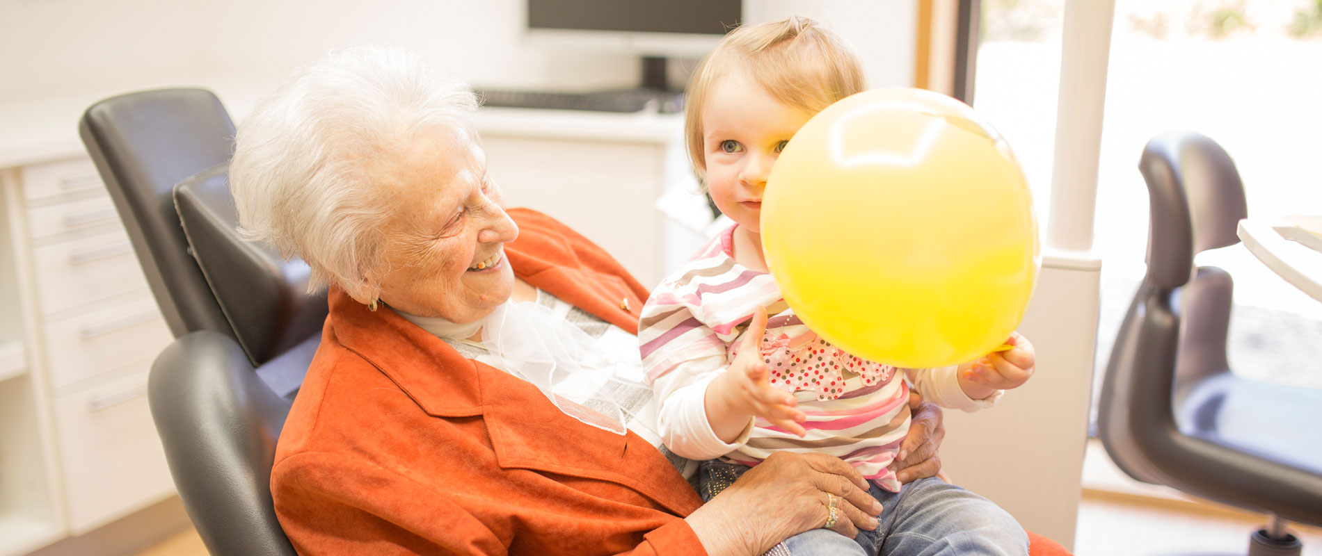 Ältere Patientin mit Kind im Zahnarztstuhl, Zahnarztpraxis in Hollfeld.