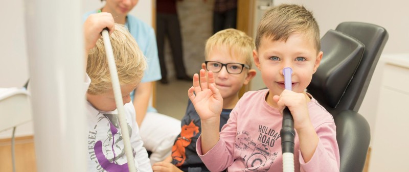 Kinder erhalten Lachgasbehandlung in Zahnarztpraxis.